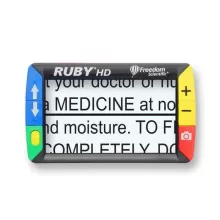 Görüntüde, "RUBY HD" marka bir büyüteç cihazı yer alıyor. Ekranında büyük yazılarla "MEDICINE" kelimesi görülüyor. Cihazın kenarlarında mavi, yeşil, sarı ve kırmızı renkli butonlar bulunuyor. Sol tarafta yukarı ve aşağı oklarla kontrol butonları, sağda ise büyütme (+) ve küçültme (-) butonları var. Cihazın üst kısmında "Freedom Scientific" logosu mevcut.